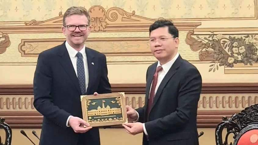 Phó Chủ tịch UBND TPHCM Hoàng Nguyên Dinh trao quà lưu niệm tặng Bộ trưởng Bộ Phát triển bang Nam Australia Chris Picton. Ảnh: THỤY VŨ