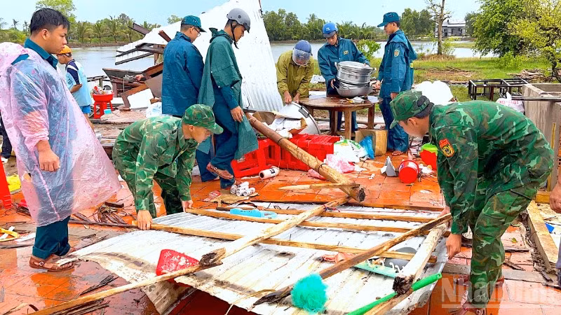 Cán bộ, chiến sĩ Đồn biên phòng Khánh Tiến chung tay cùng địa phương giúp người dân khắc phục hậu quả sau thiên tai.
