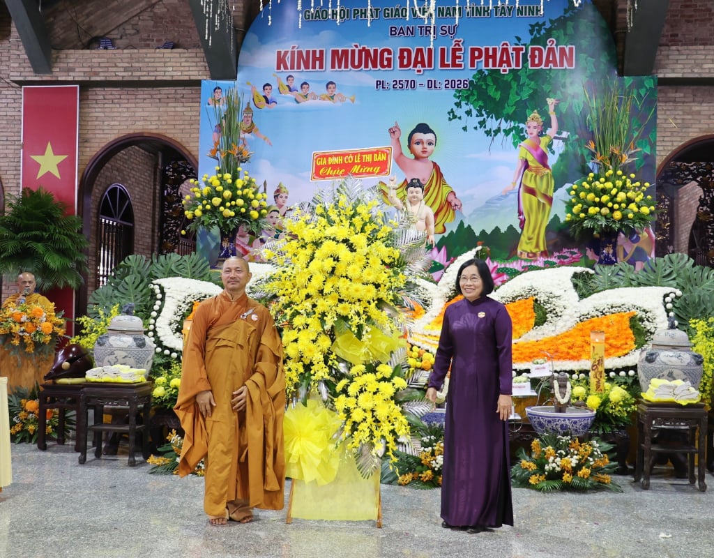 La exsecretaria del Comité Provincial del Partido de Tay Ninh, Nguyen Thi Minh, entrega flores para felicitar a la pagoda Thien Lam Go Ken por la celebración del cumpleaños de Buda.