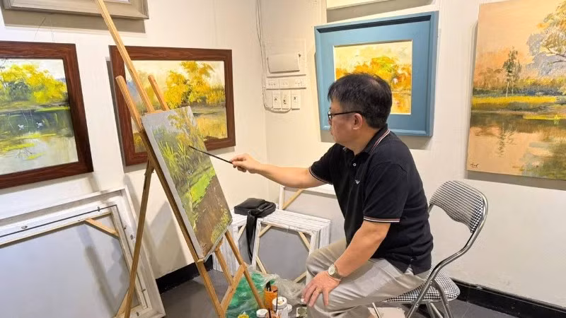 L'artiste Quynh Thom peint dans l'espace d'exposition « Couleurs de la campagne 11 ».
