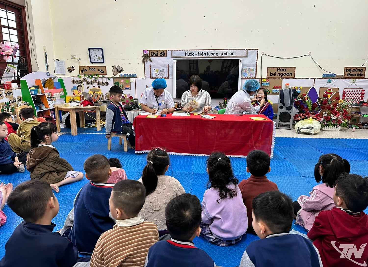 फुंग ची किएन किंडरगार्टन में चिकित्सा कर्मचारी छात्रों की स्वास्थ्य जांच करते हैं।