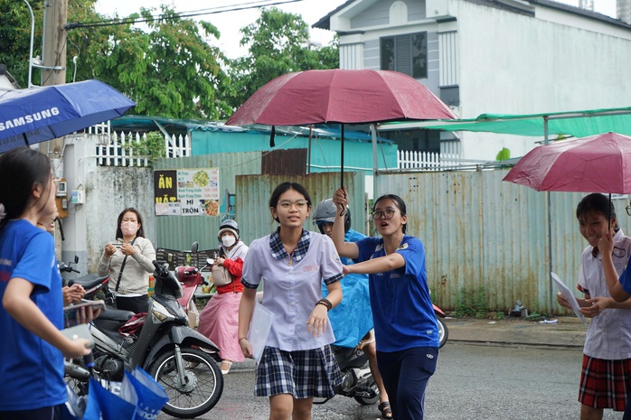Mưa bất chợt, học sinh vẫn đội mưa tiếp sức thí sinh - Ảnh 4.