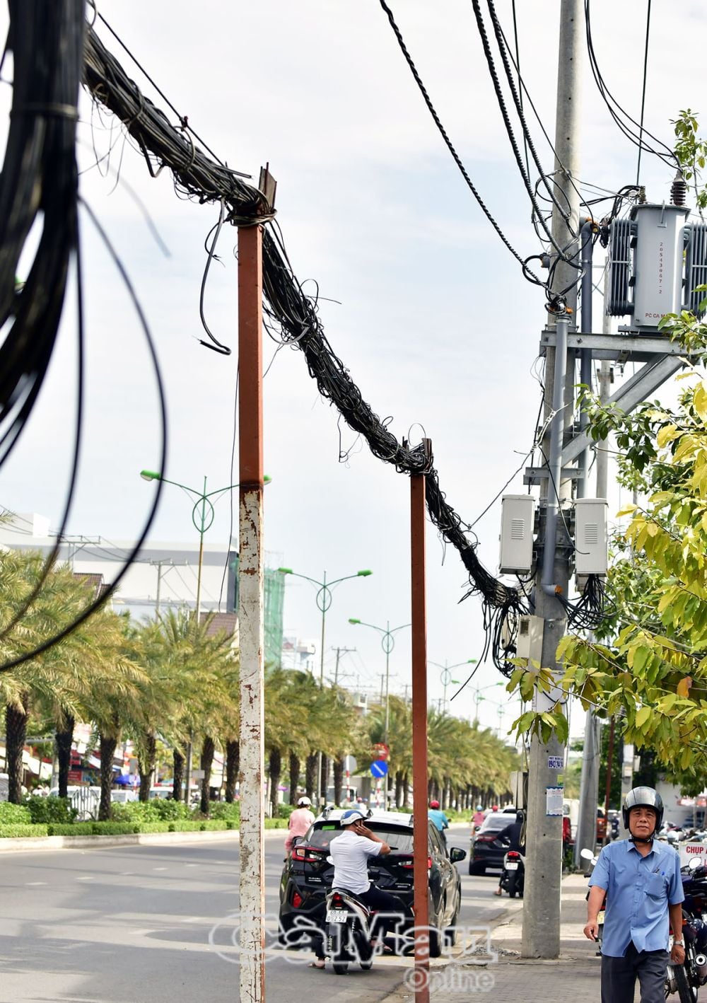 Das Kabel ist zu schwer und hängt bis zur Fahrbahn herunter, weshalb provisorische Stützen erforderlich sind, was sowohl unsicher als auch unansehnlich ist. (Foto aufgenommen vor dem Gebäude der Quang Tien Construction Co., Ltd., Nguyen Tat Thanh Straße, Bezirk 8).