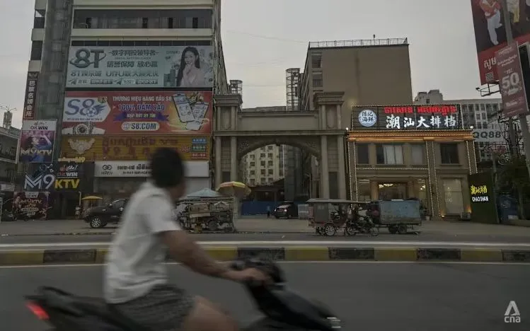 Một người đàn ông đi ngang qua biển quảng cáo cờ bạc trực tuyến bất hợp pháp tại Bavet, Campuchia, tháng 5/2026. (Ảnh: CNA)