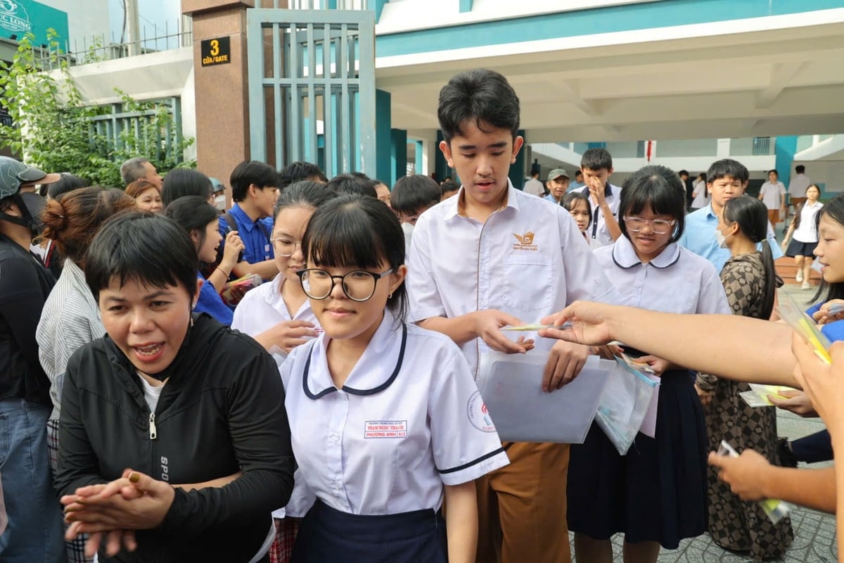 Sau 120 phút làm bài môn toán, nhiều thí sinh rời điểm thi và trao đổi nhanh về bài làm trước khi ra về. Ảnh: Trần Phi.