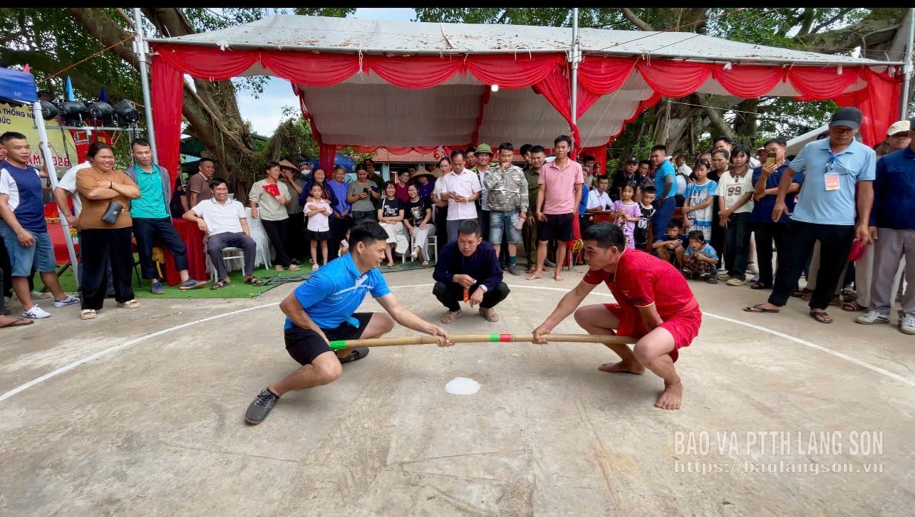 Les gens participent au jeu de poussée de bâtons lors du festival.