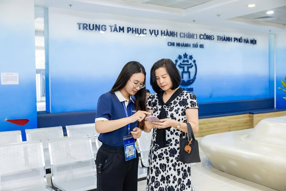Người dân được TNV hướng dẫn thực hiện khảo sát ngay sau khi thực hiện thủ tục hành chính công. Ảnh: BTC.
