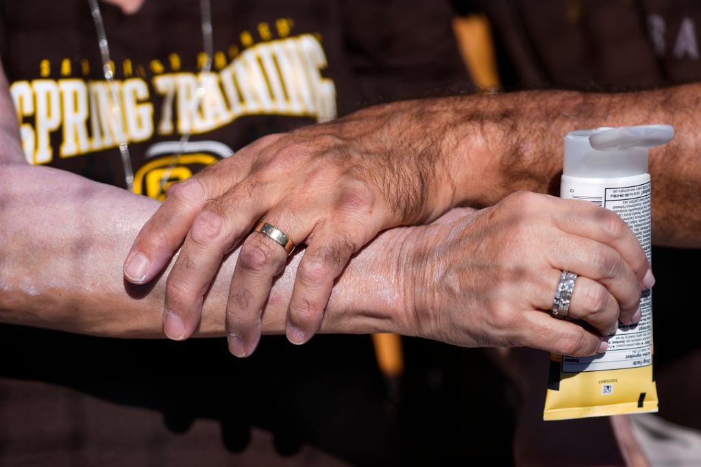 Un uomo applica la crema solare sul braccio di una donna prima di una partita di baseball tra i San Diego Padres e i Chicago White Sox a Phoenix, in Arizona, Stati Uniti. Foto: AP