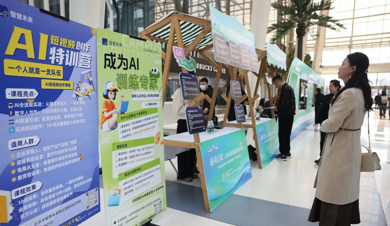 Seorang wanita melihat iklan untuk kursus latihan AI intensif di sebuah pameran pekerjaan di Beijing, 20 Mac 2026. Sumber: VCG. Một phụ nữ xem thông tin quảng cáo về các khóa đào tạo chuyên sâu AI tại hội chợ việc làm ở Bắc Kinh, ngày 20/3/2026. Nguồn: VCG.