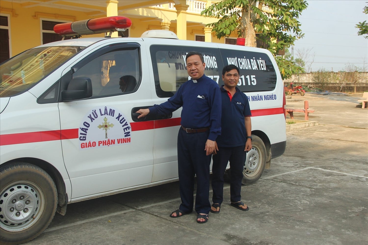 Linh mục Nguyễn Xuân Phương (trái) và anh Nguyễn Đình Quảng bên chiếc xe cứu thương miễn phí, khi còn ở Giáo xứ Lâm Xuyên.jpg