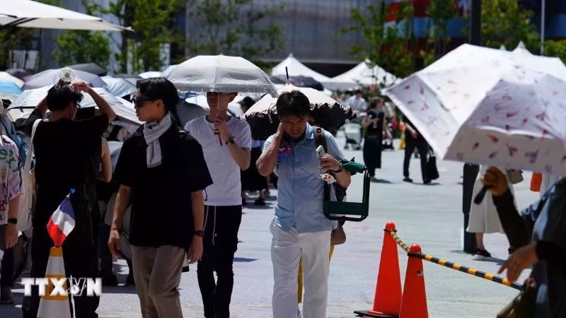 Pedestrians use umbrellas to shield themselves from the sun in Osaka, Japan. (Photo: THX/VNA)