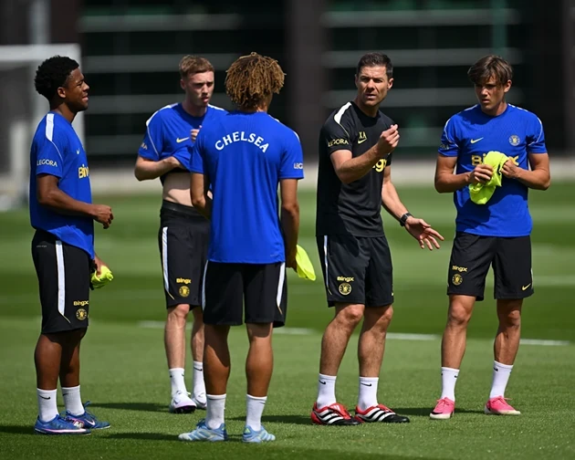 Xabi Alonso conversa com Cole Palmer e os jogadores mais jovens no campo de treinamento.