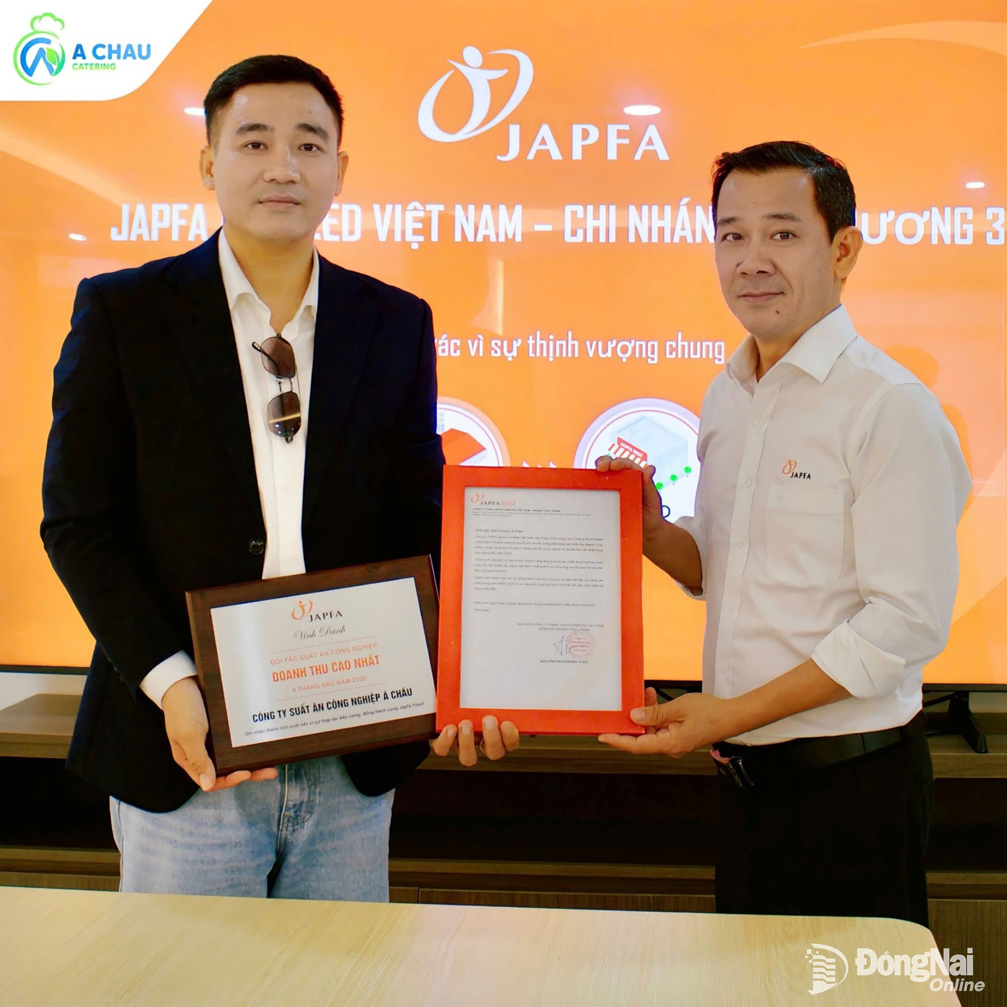 O Sr. Nguyen Anh Nguyet, Diretor da Fábrica de Alimentos JAPFA, filial de Binh Duong, entregou uma carta de congratulações e uma placa comemorativa na categoria de Parceiro de Alimentação Industrial com Maior Receita no primeiro semestre de 2026 ao Sr. Nguyen Xuan Dao, Presidente do Conselho de Administração da Asia Food Trading & Services Co., Ltd. (Foto: Thanh Vy)  