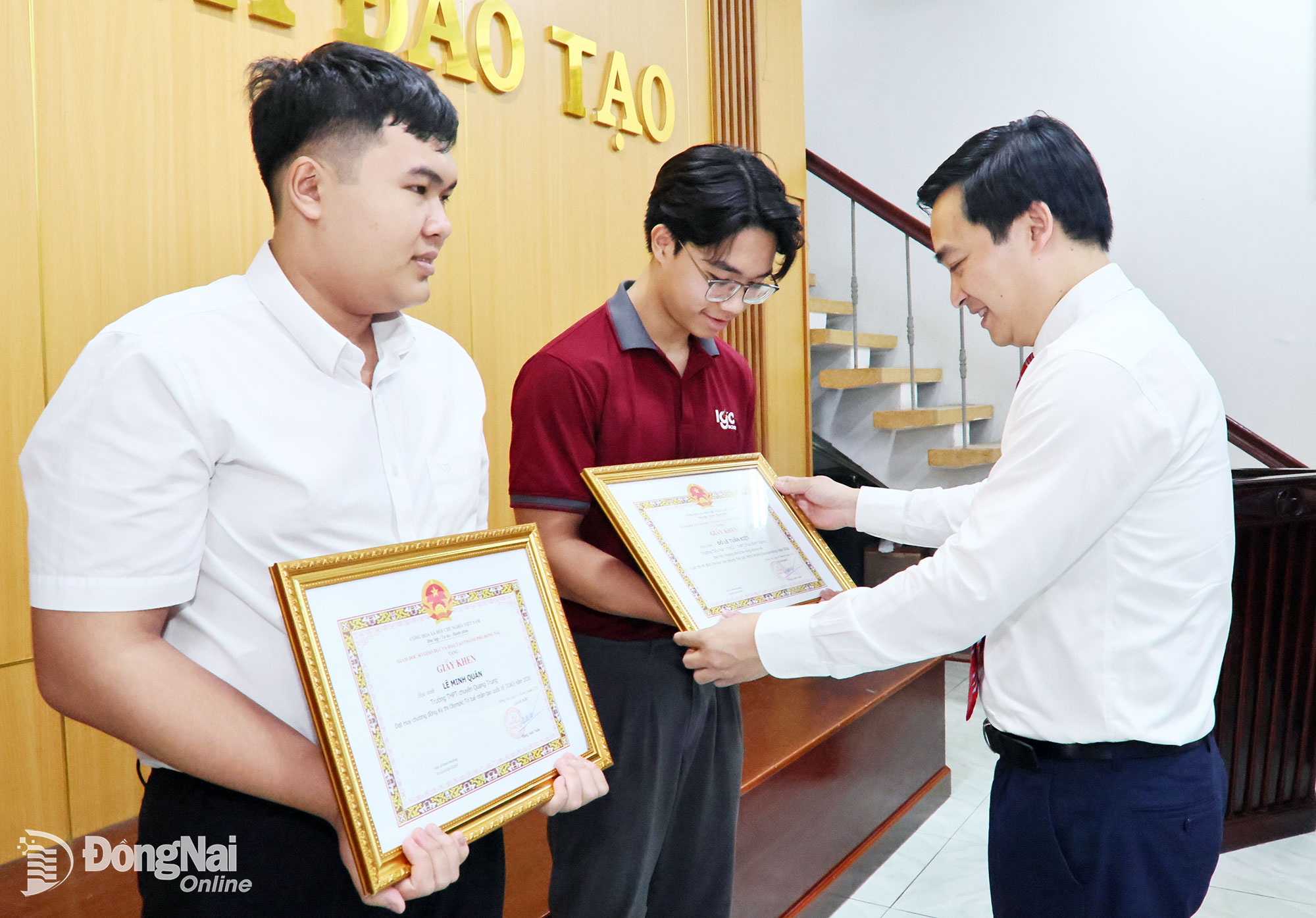 O Dr. Dang Anh Tuan, Diretor do Departamento de Educação e Formação, entrega certificados de mérito a dois alunos que obtiveram sucesso em competições internacionais. Foto: Cong Nghia