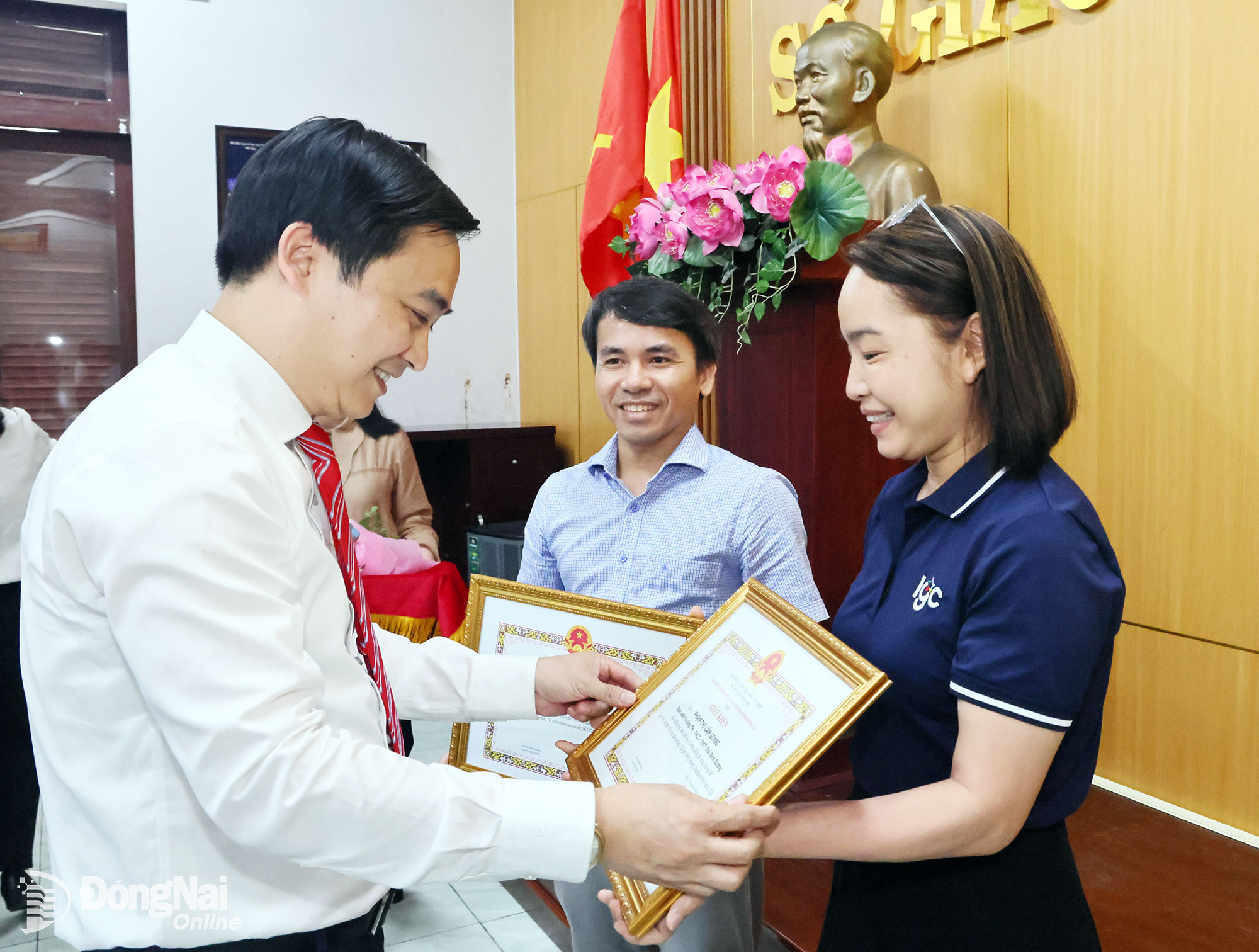 O Dr. Dang Anh Tuan, Diretor do Departamento de Educação e Formação, entrega certificados de reconhecimento a dois professores que acompanharam alunos em competições internacionais. Foto: Cong Nghia