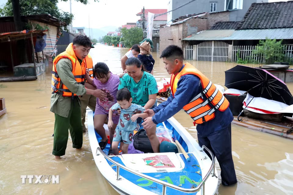 Lực lượng chức năng xã Tràng Định, tỉnh Lạng Sơn, hỗ trợ đưa người dân từ vùng ngập sâu đến nơi an toàn. (Ảnh: Văn Đạt/TTXVN)
