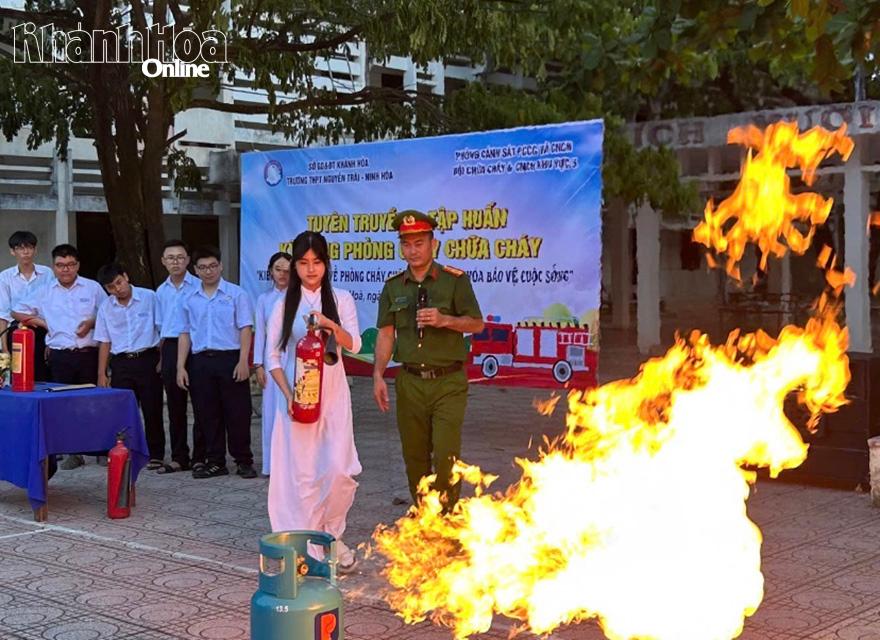 Dưới sự hướng dẫn của cán bộ, các em học sinh được trải nghiệm kỹ năng dùng bình chữa cháy xách tay để dập lửa.