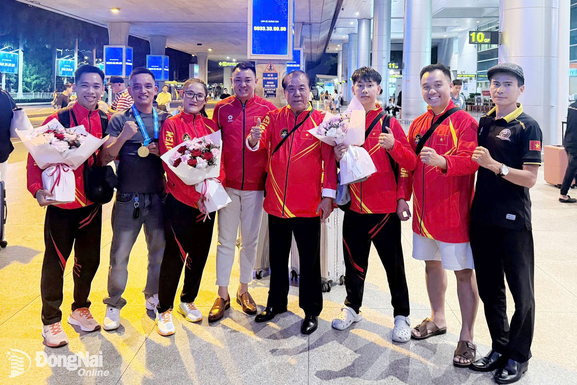 Mr. Le Trong Anh, Deputy Head of the High-Performance Sports Training Department, Dong Nai City Sports Training and Competition Center (fourth from the left), along with coaches, congratulates the Dong Nai City Traditional Martial Arts Team at Tan Son Nhat Airport. Photo: Provided by the team.