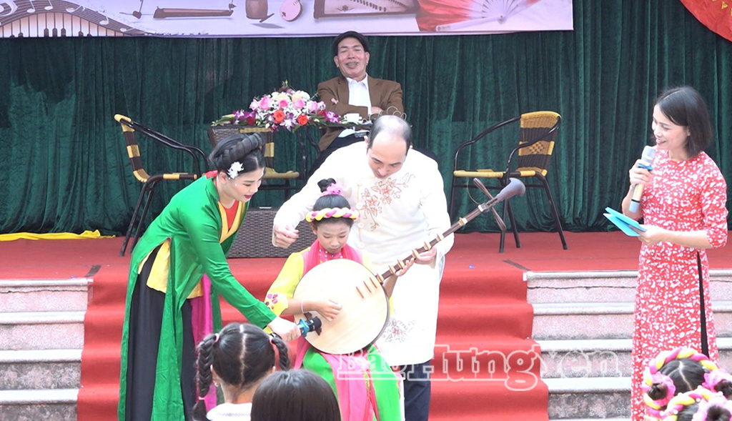 Học sinh Trường Tiểu học An Vinh (xã Quỳnh An) được các nghệ sĩ giới thiệu nhạc cụ dân tộc.